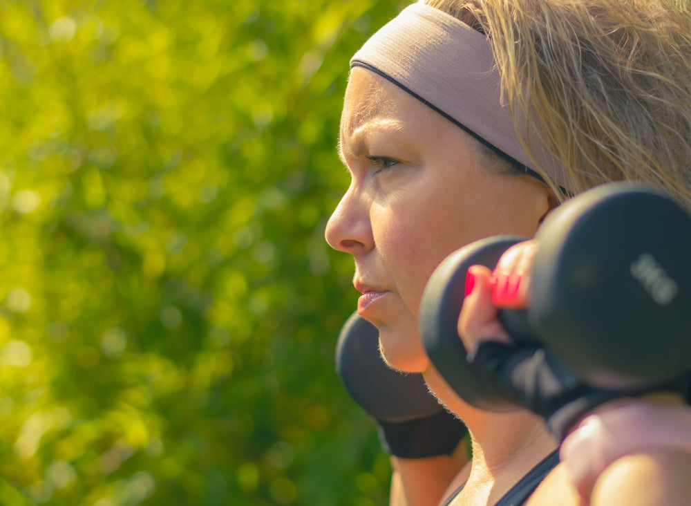 woman in white tank top with black headphones