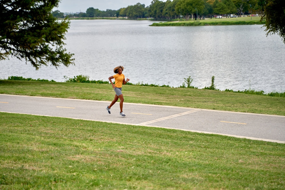 a person running on a path near a body of water