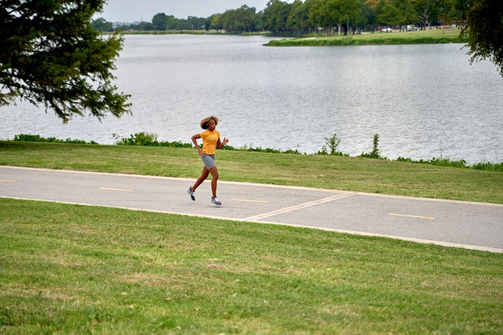 a person running on a path near a body of water