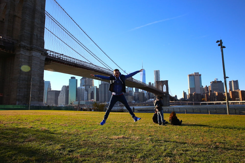 a man jumping in the air in front of a bridge