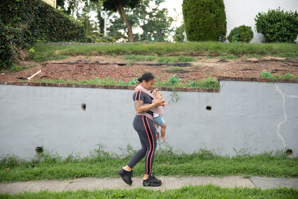 a person holding a baby by a pond