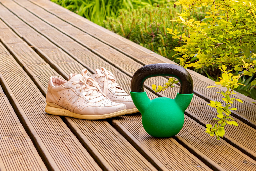 a pair of shoes sitting on a wooden bench next to a watering can