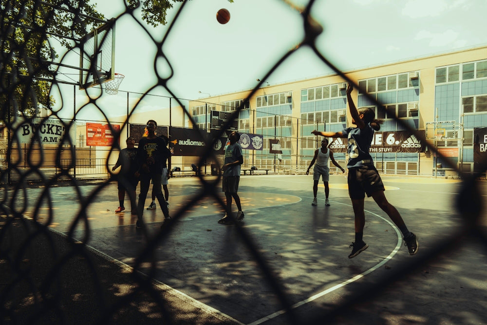 People are playing basketball on an outdoor court.